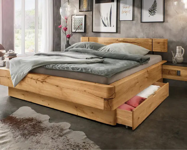 Modernes Massivholzbett mit integriertem Bettkasten und grauer Bettwäsche in stilvollem Schlafzimmer mit Wandbildern und dekorativer Beleuchtung